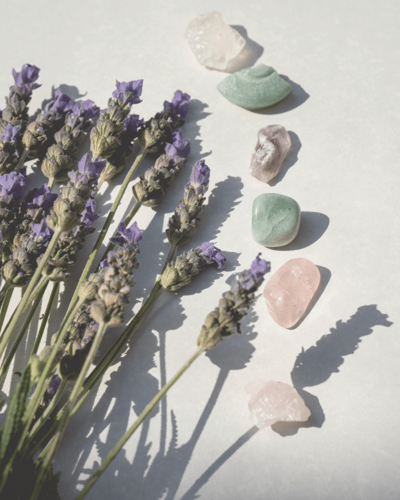 A soft flat lay of lavender flowers and healing crystals in sunlight, symbolising calm, emotional healing, and self-care during recovery from domestic abuse.