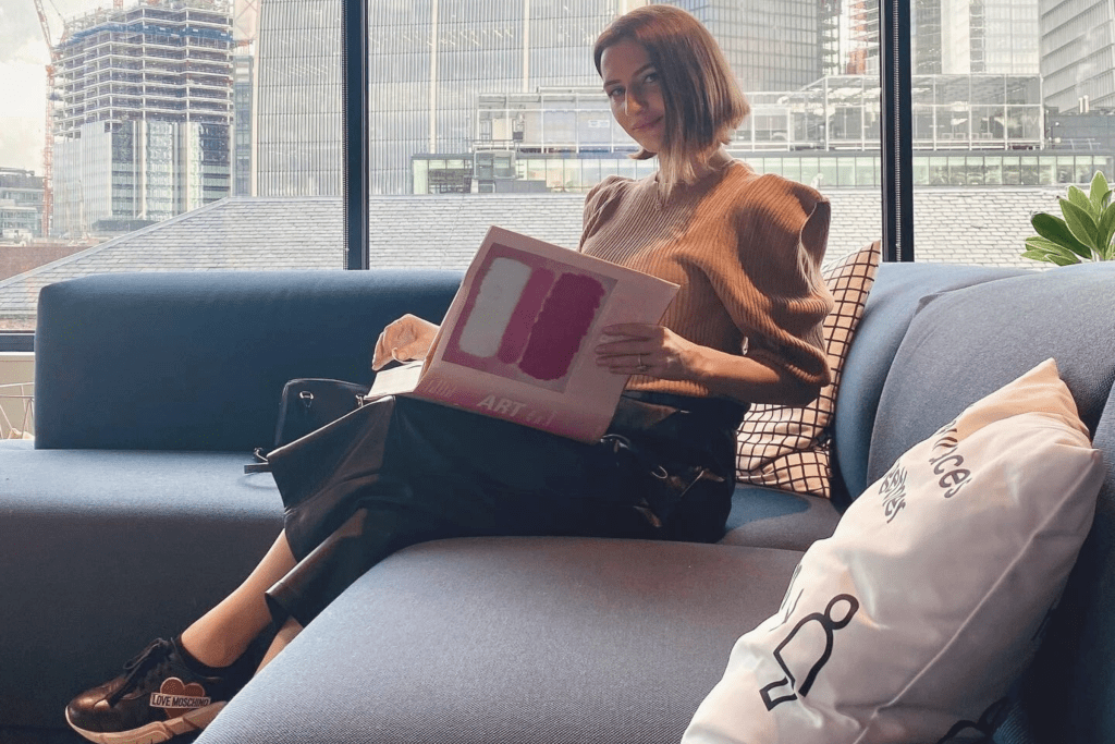 Madalina in quiet reflection, immersed in her work, with the London skyline behind; embodying calm, presence, and renewal.