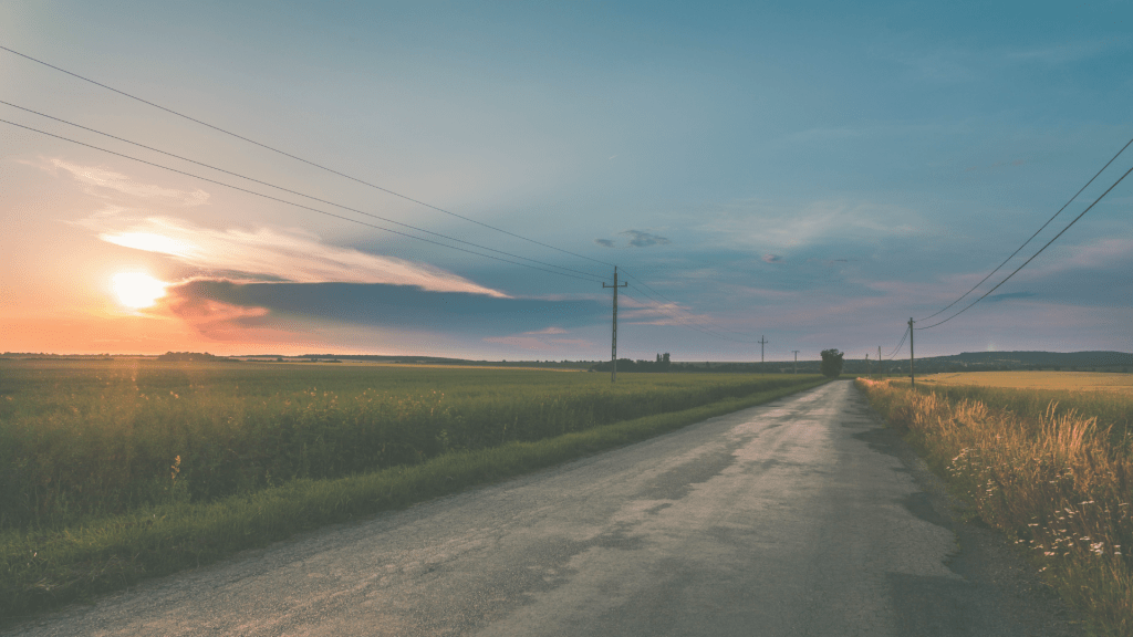 Empty country road at sunset symbolising life in a state of low-grade alert and long-term nervous system stress