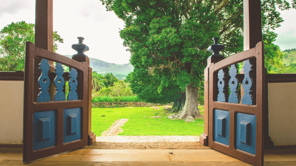 Open doorway leading to a green outdoor space, representing access to support and safety resources